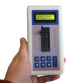 D2260 Professional Integrated Circuit IC Tester Transistor Tester Online Maintenance Digital LED Transistor IC Tester - held in a hand, featuring a white rectangular body, a ZIF socket, a keypad, and a screen displaying "Seach ] [Auto ] self-check pass".