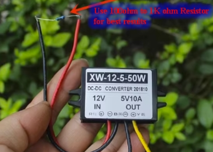DC-DC 12V To 5V 10A Step Down Buck Converter Power Regulator - with a black rectangular casing, four wires, and a resistor connected between the red and black input wires.