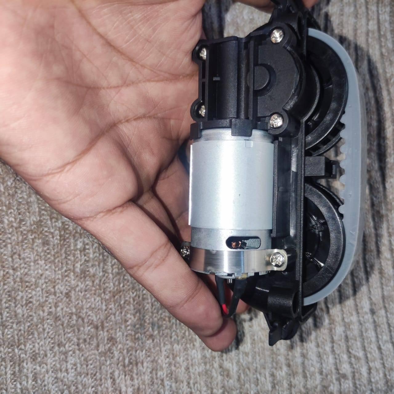 DC Gear Motor With 3.7V To 12V Operated - a silver cylindrical motor attached to a black plastic gear assembly with a grey rubber belt.