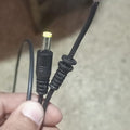 DC Male Power Connector DC Jack With 1 Meter Wire - a close-up of a black DC barrel plug and a cut wire end with exposed copper strands.