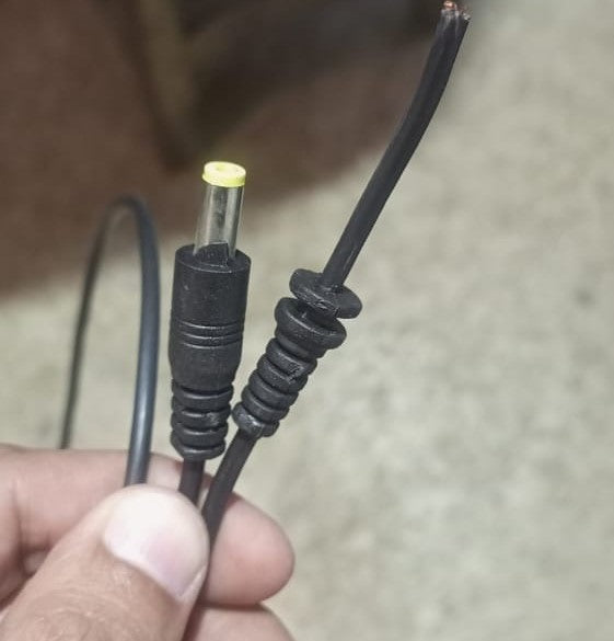 DC Male Power Connector DC Jack With 1 Meter Wire - a close-up of a black DC barrel plug and a cut wire end with exposed copper strands.