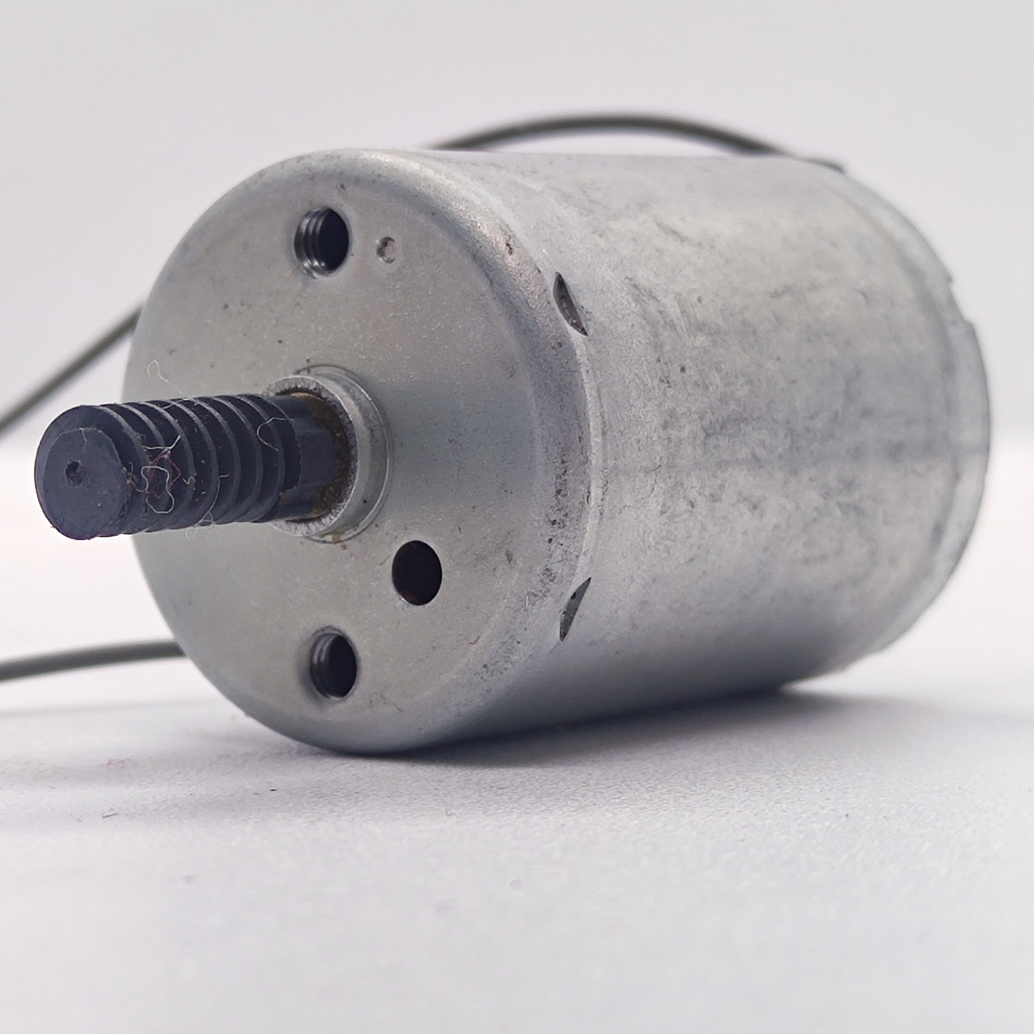 DC Motor 2V To 24V 5100RPM - a silver cylindrical DC motor with a black plastic worm gear on the shaft and two wire leads extending from the back.