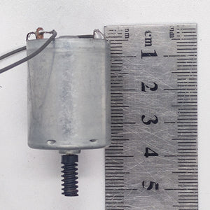 DC Motor 2V To 24V 5100RPM - shown as a silver cylindrical motor with a black worm gear on the shaft, placed next to a metal ruler for scale.