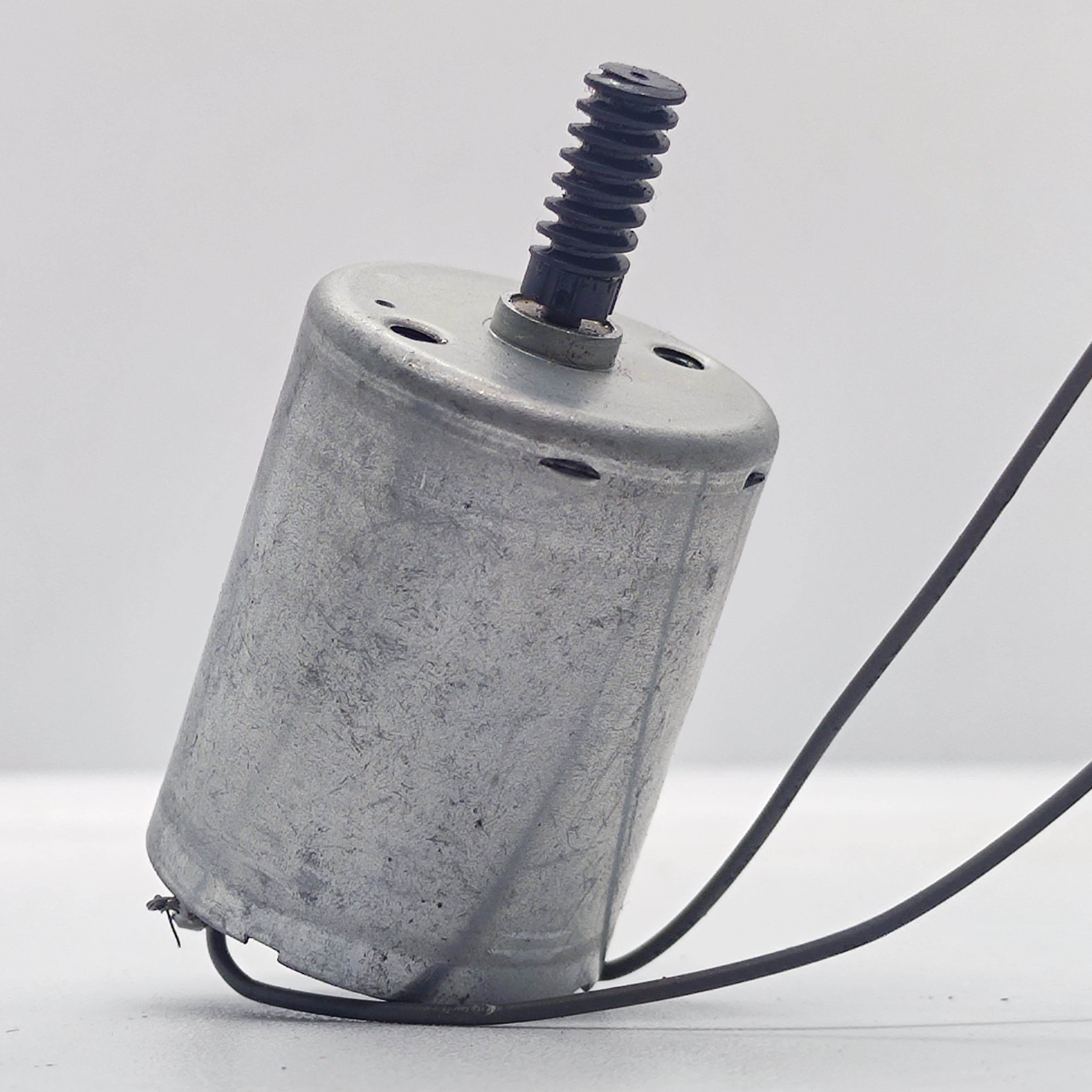 DC Motor 2V To 24V 5100RPM - a silver cylindrical motor with a black worm gear on the shaft and two black wires extending from the base.