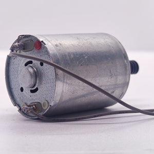 DC Motor 2V To 24V 5100RPM - a silver cylindrical motor with two electrical terminals soldered to grey wires and a small black gear on the output shaft.