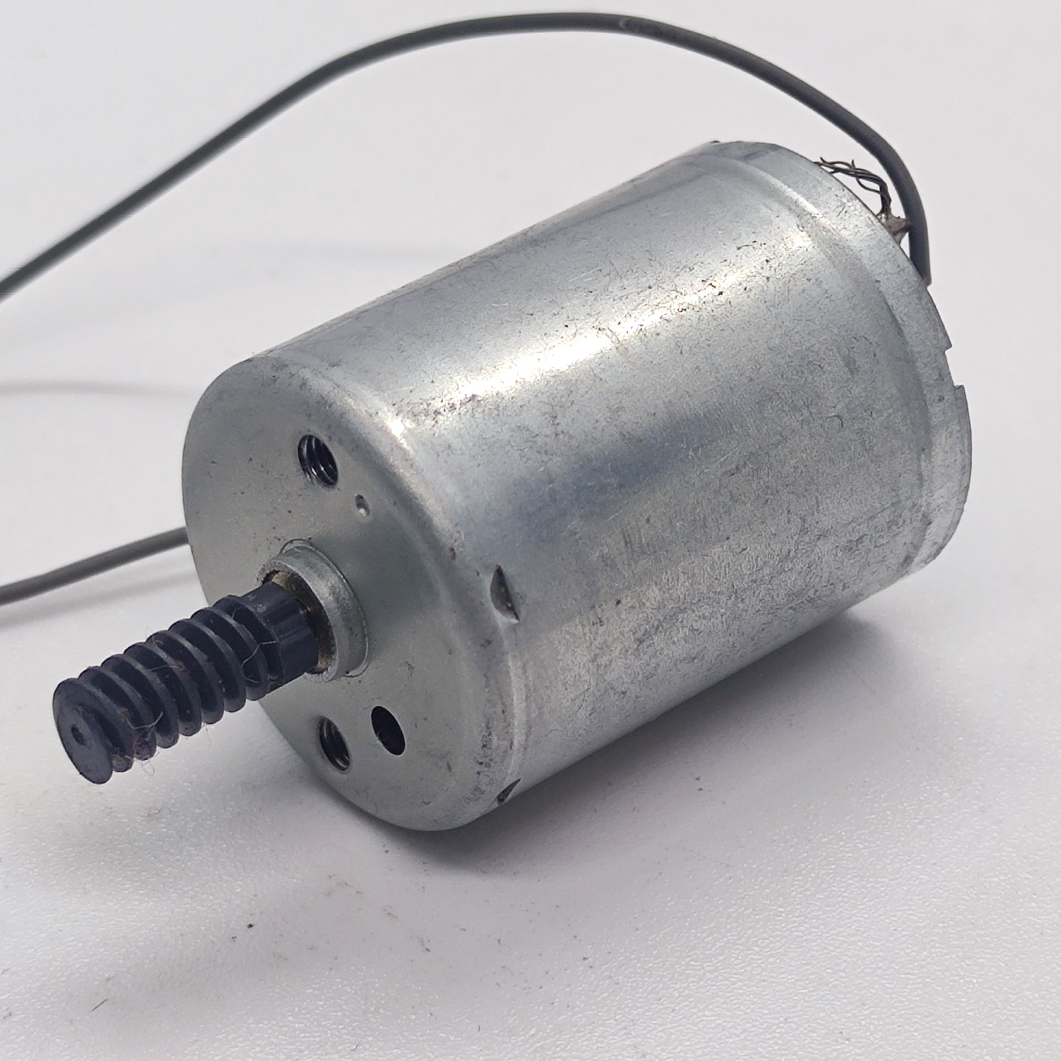 DC Motor 2V To 24V 5100RPM - a cylindrical silver metal motor with a black plastic worm gear on the shaft and two thin wires attached.