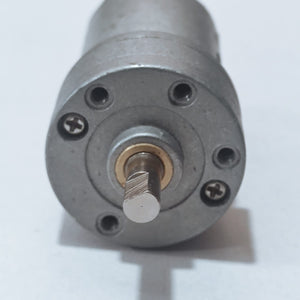 DC Motor DC Electric Geared Motor - a close-up shot of the silver metallic front face showing the circular mounting holes and the D-shaped output shaft.