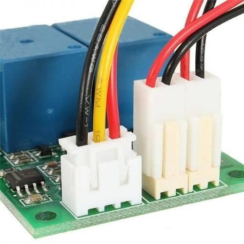DC Motor Speed And Direction Controller Board - a close-up of the green circuit board, blue relays, and three white wire harness connectors.