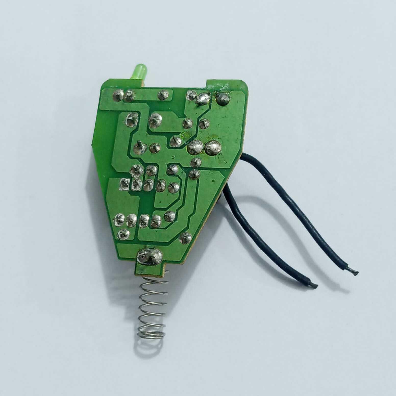 DC To DC Convertor IC 34063A - a green circuit board with a metal spring contact, two black wires, and a small LED component.