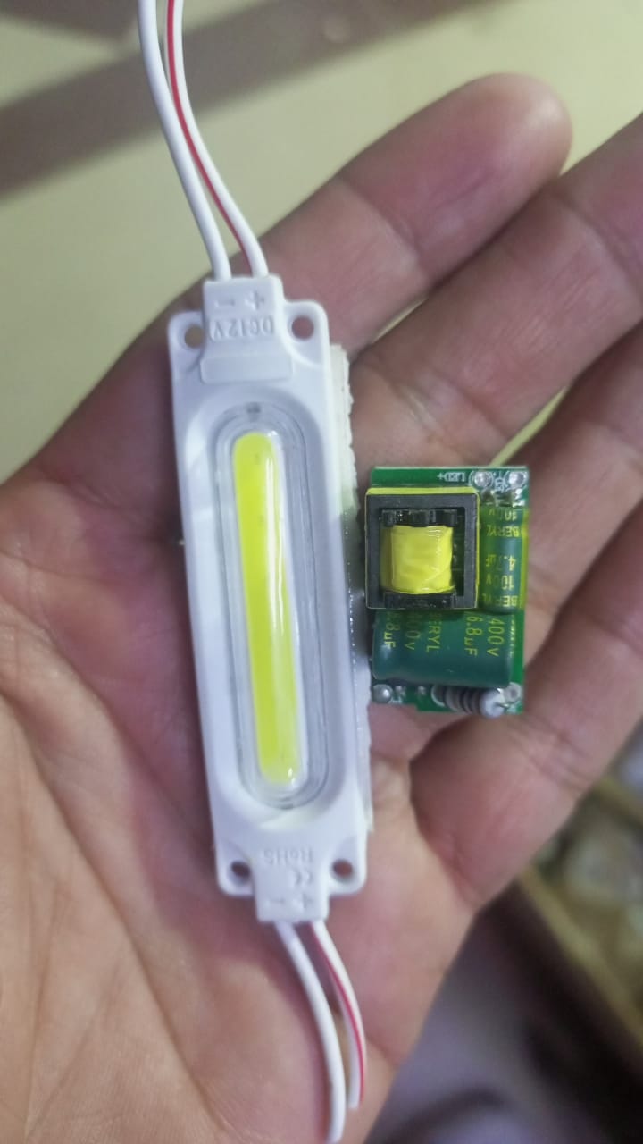 Decoration Lights Lamp LED Light For Decoration Pieces - shown as a white LED module with wires held next to a small green circuit board with a transformer.