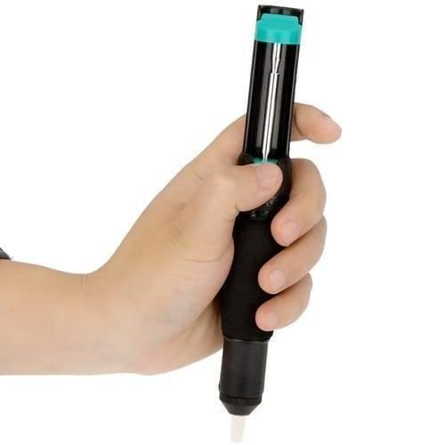 Desoldering Pump Vaccum Solder Sucker - Vacuum Solder Sucker held in a hand, showing a black cylindrical body with a teal plunger handle and a white nozzle.