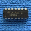 Differential Comparator IC LM2901N - a black 14-pin dual-in-line integrated circuit chip with white text markings, resting on a blue textured surface.