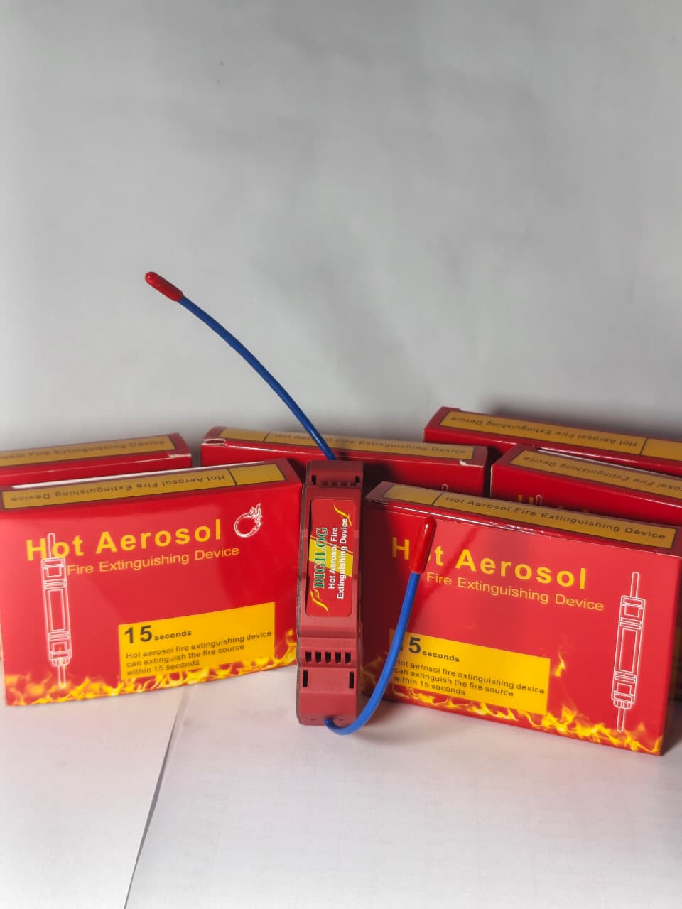 DIGILOG QRR0.01G Heat Aerosol Fire Extinguishing Device - shown with two red boxes and one central unit featuring a blue wire and a red tip.