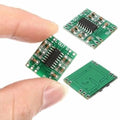 Digital Stereo Audio Amplifier Board PAM8403 Mini Two Channel 2x3w Class d Audio Power Amplification Module - three small green circuit boards with chips and labeled input/output pads, held by a hand.