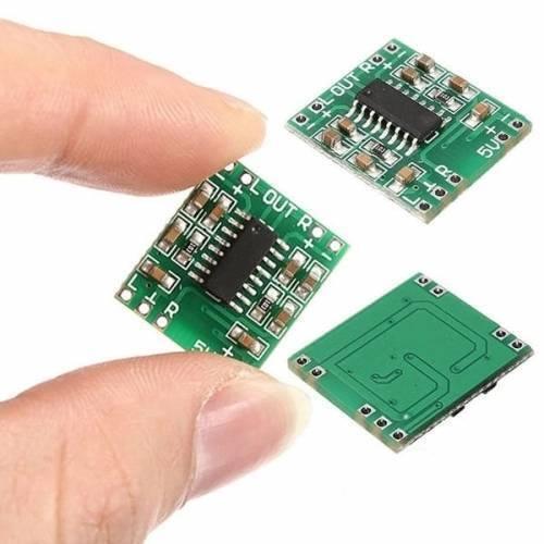 Digital Stereo Audio Amplifier Board PAM8403 Mini Two Channel 2x3w Class d Audio Power Amplification Module - three small green circuit boards with chips and labeled input/output pads, held by a hand.