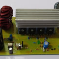 Discontinued Local Inverter Booster With Power Supply - a green circuit board with large capacitors, a red inductor coil, and a central heatsink.