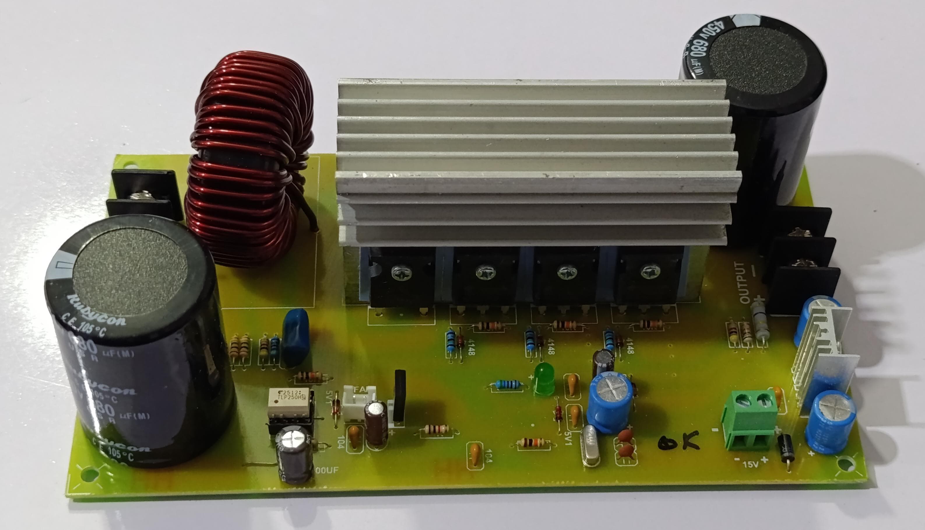 Discontinued Local Inverter Booster With Power Supply - a green circuit board with large capacitors, a red inductor coil, and a central heatsink.