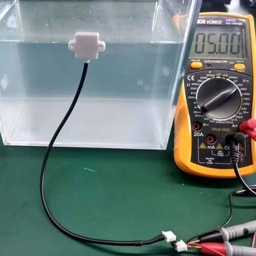 Discontinued Mini 5V Liquid Water Level Sensor Detection Switch With Alarm XKC-Y23-V - connected to a yellow digital multimeter displaying 05.00.