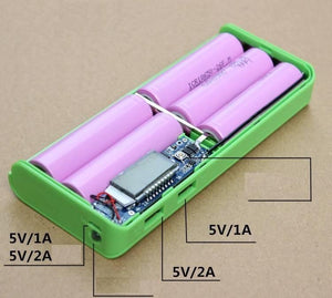 Solderless LCD Display Dual USB DIY Power Bank Module - a green open case with four pink 18650 batteries, a circuit board, and two USB ports.