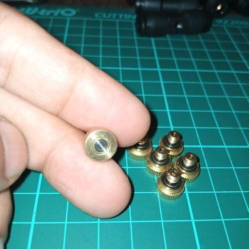 Disinfection Gate Misting System Accessory With Brass Nozzle - a close-up of a gold-colored brass nozzle with a black O-ring held by fingers.
