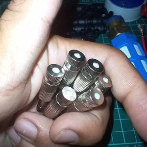 Disinfection Gate Misting System Accessory With Brass Nozzle - a close-up of several silver-coloured metal misting nozzles held in a hand.
