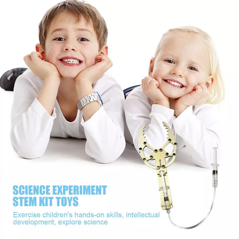 DIY Hydraulic Manipulator Wooden STEM Kit Unassembled - a boy and girl behind an assembled gold-colored wooden claw toy with a syringe control.