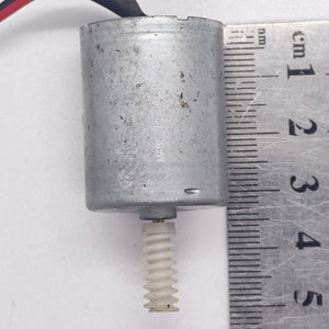 DIY Mini 5vdc DC Motor - shown next to a metal ruler to indicate its size, featuring a silver cylindrical body and a white plastic worm gear on the shaft.