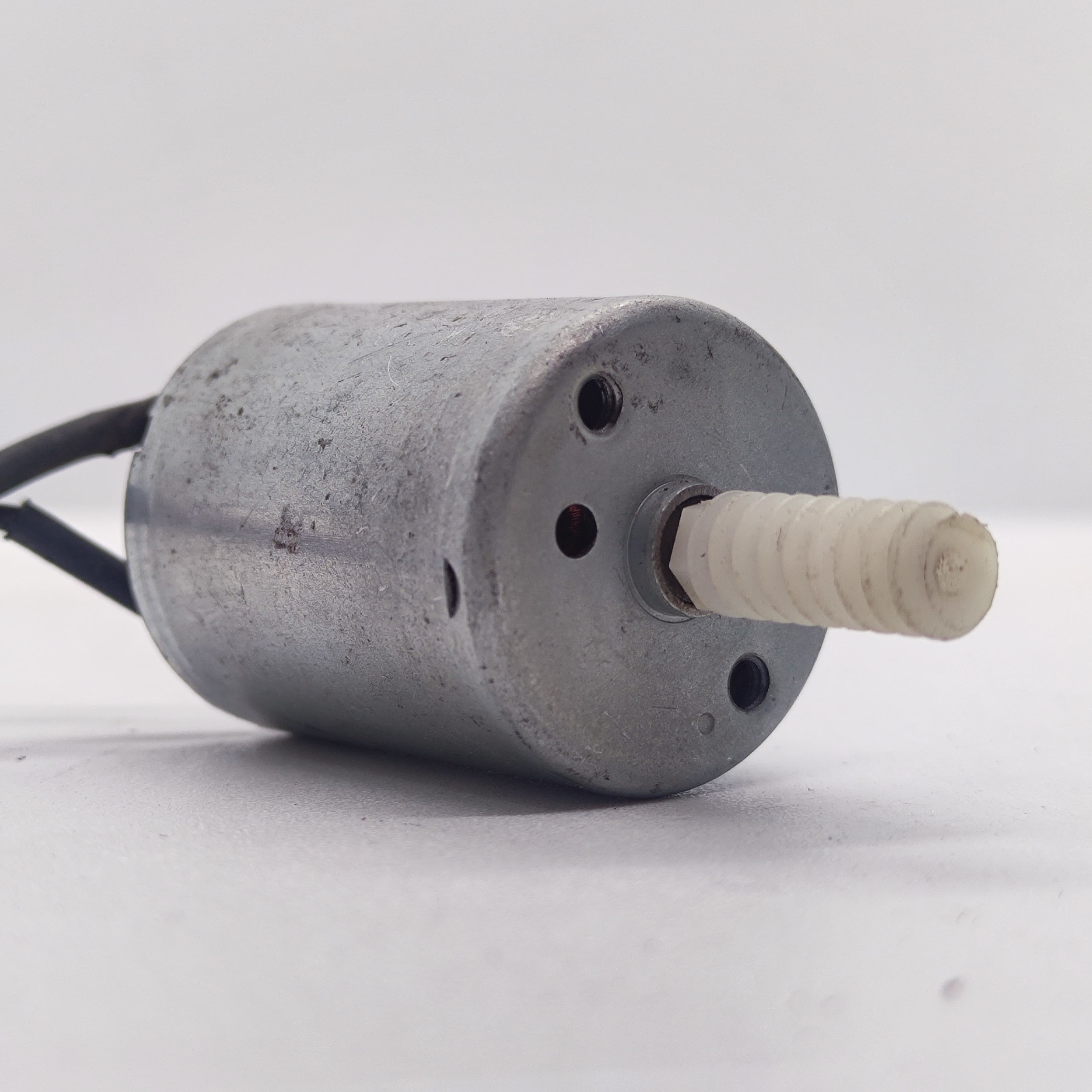 DIY Mini 5vdc DC Motor - shown as a silver cylindrical motor with two black wires and a white plastic worm gear attached to the rotating shaft.
