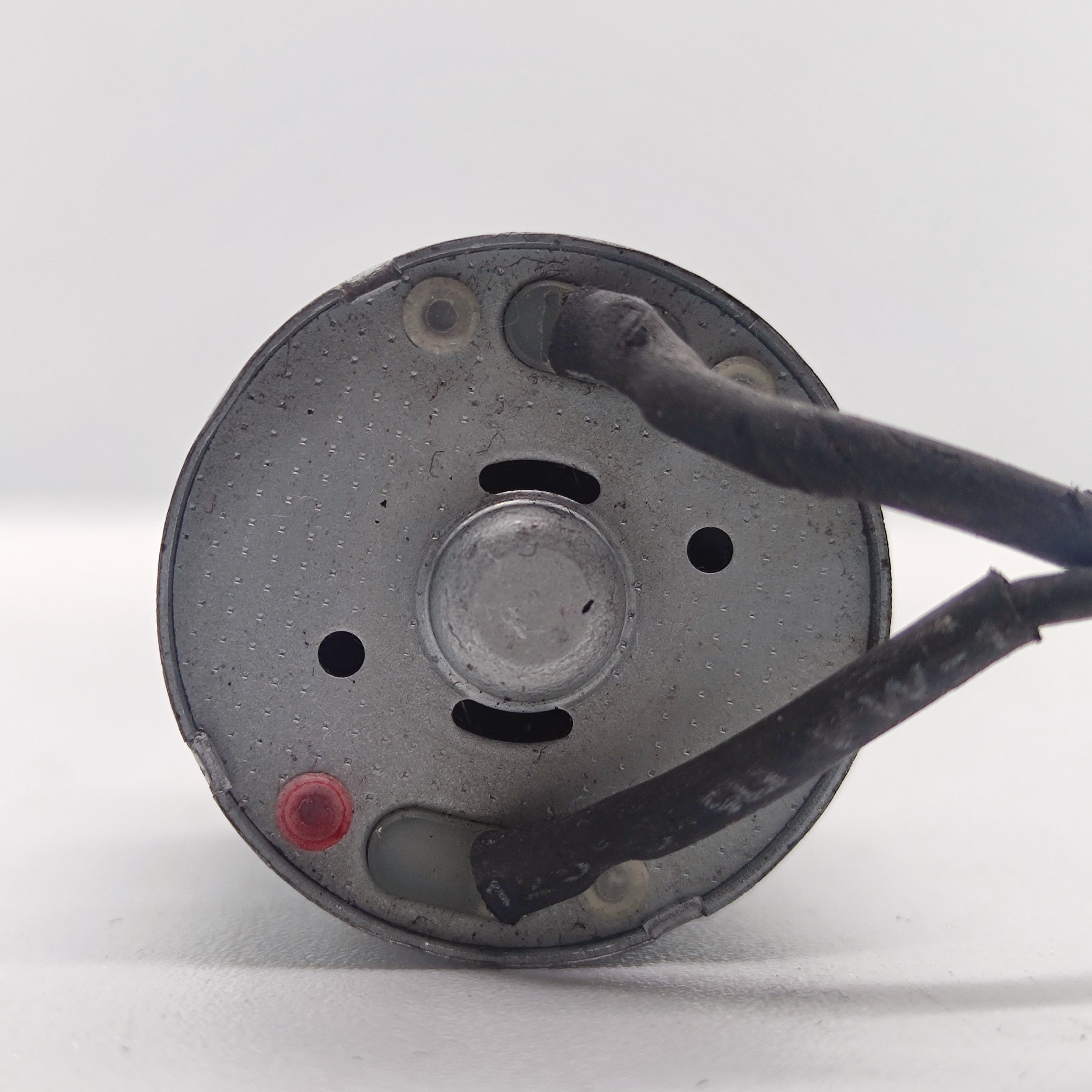 DIY Mini 5vdc DC Motor - a close-up view of the circular rear end showing two wire terminals, a red indicator dot, and ventilation slots.
