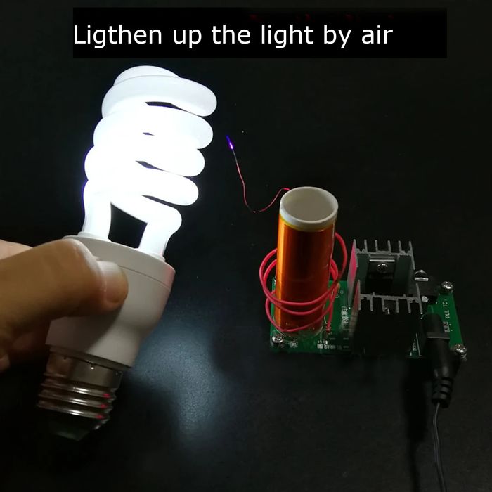 DIY Mini Tesla Coil Plasma Speaker Kit Unassembled - a hand holding a glowing spiral light bulb near a powered copper coil and circuit board.