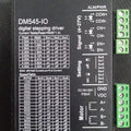 DM545-IO 18-50V/DC 4.5A 2-phase Stepper Motor Driver - a black rectangular module featuring a printed current and speed configuration table, side terminal blocks, and DIP switches.