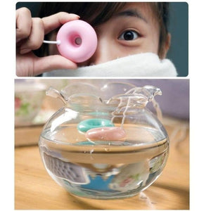 Donuts Shape Mini USB Humidifier Mist Maker Air Diffuser - shown as a pink donut-shaped device held by a person and floating in a glass bowl of water.