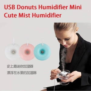 Donuts Shape Mini USB Humidifier Mist Maker Air Diffuser - pink, and blue, shown floating and emitting mist in a glass held by a woman.