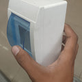 Double Pole Breaker Fitting Box - a white plastic enclosure held in a hand featuring a hinged, translucent blue protective cover.