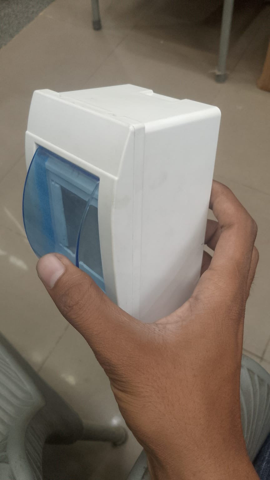 Double Pole Breaker Fitting Box - a white plastic enclosure held in a hand featuring a hinged, translucent blue protective cover.