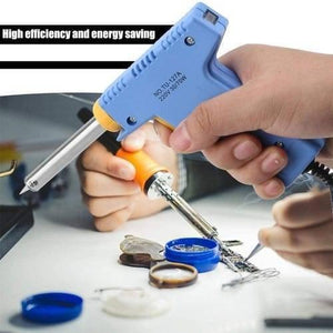 Dual Wattage Electric Temperature Gun Soldering Iron TU-127A - held in a hand while being used to solder a circuit board with a blue flux container nearby.