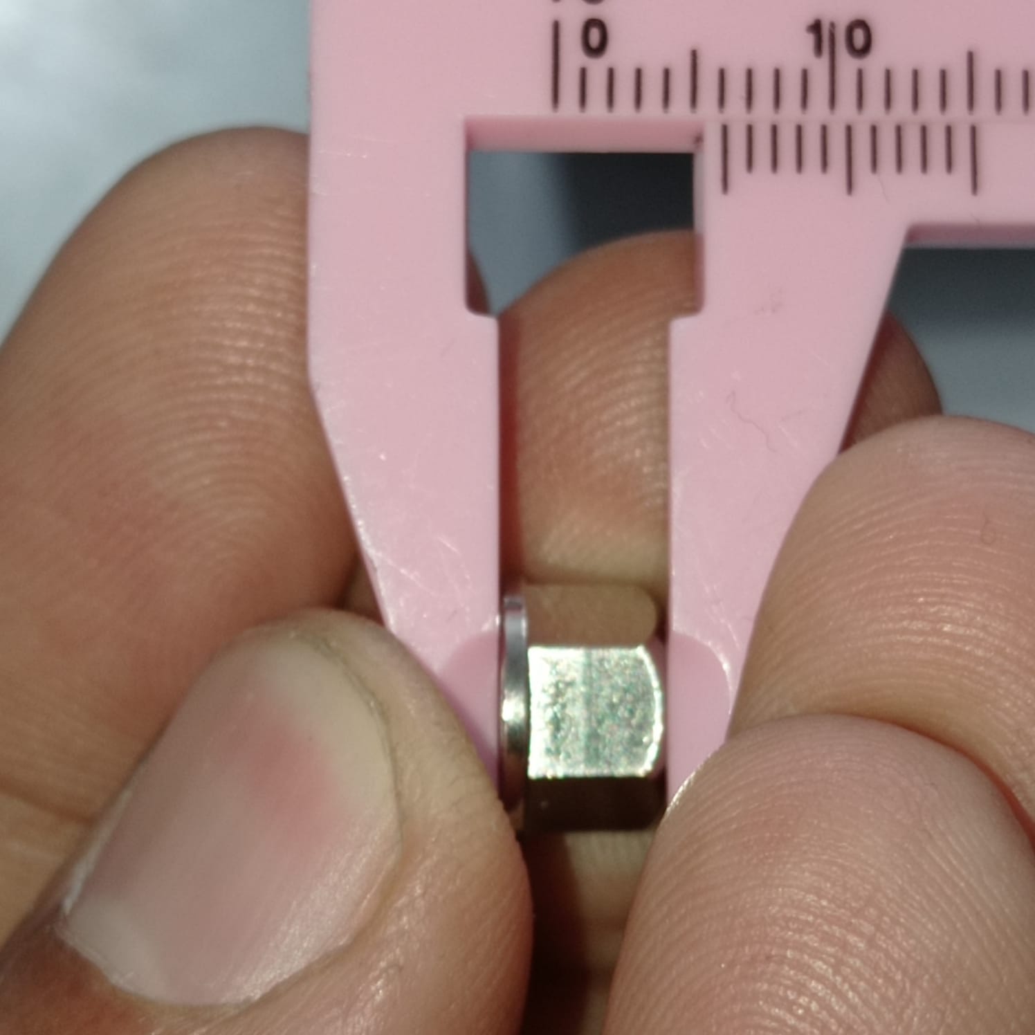Eccentric Sleeve Type A 8X6 Spacer Eccentric for structural profile under V-slot OpenBuilds 6 mm engraved - shown in a close-up being measured by a pink plastic vernier caliper.