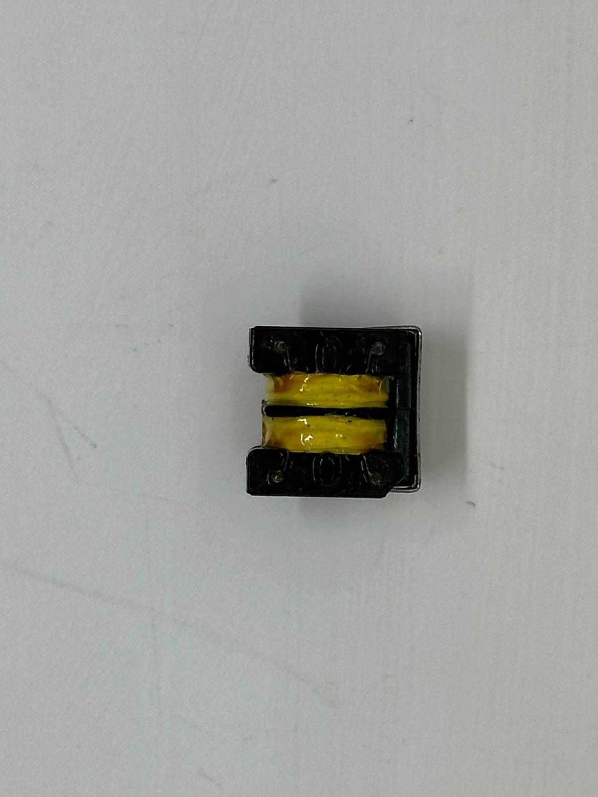 EE16 Pulse Transformer LFU10H-203U 0.45A - a close-up view of a small black electronic component with two yellow-wrapped copper wire coils.
