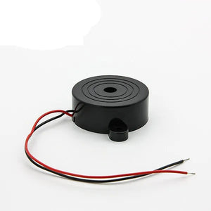 Electronic Buzzer Beep Alarm 3V To 24V - a round black buzzer with a small mounting tab and two attached red and black wires.