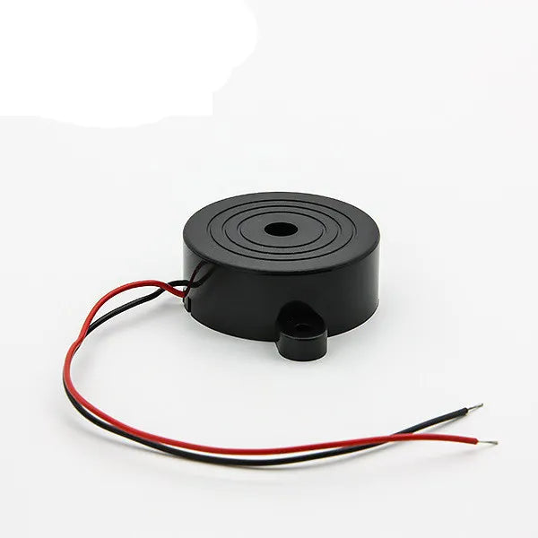 Electronic Buzzer Beep Alarm 3V To 24V - a round black buzzer with a small mounting tab and two attached red and black wires.