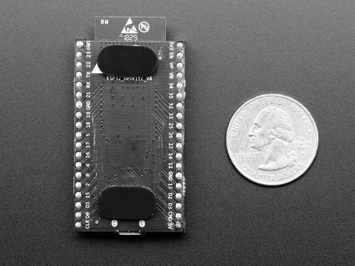 Espressif ESP32 Wroom 32D Development Board - shown from the bottom, featuring a black PCB with labeled pins and a micro-USB port next to a US quarter.