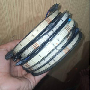 Faulty RGB LED Strip Lot 5 Meter 5 Meter 30 LED Per Meter Dusty Lot - a coiled strip of white LED lights held in a hand with visible four-pin connectors.