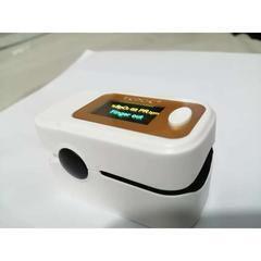 Finger Pulse Digital Oximeter-SPO2 - a white and gold device with a single button and a digital display reading "Finger out".