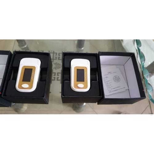 Finger Pulse Digital Oximeter-SPO2 - shown in two open black boxes, each featuring a white and gold device with a screen and a single circular button.