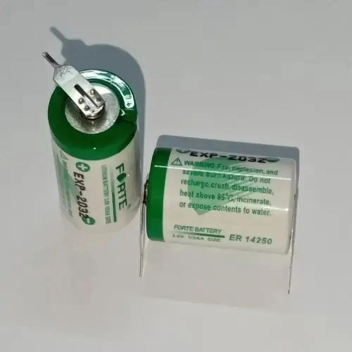 Forte ER14250 Lithium Battery, Battery Capacity: 1200mAh, Voltage: 3.6V - two white and green 3.6V 1/2AA size batteries with metal soldering pins standing on a white surface.