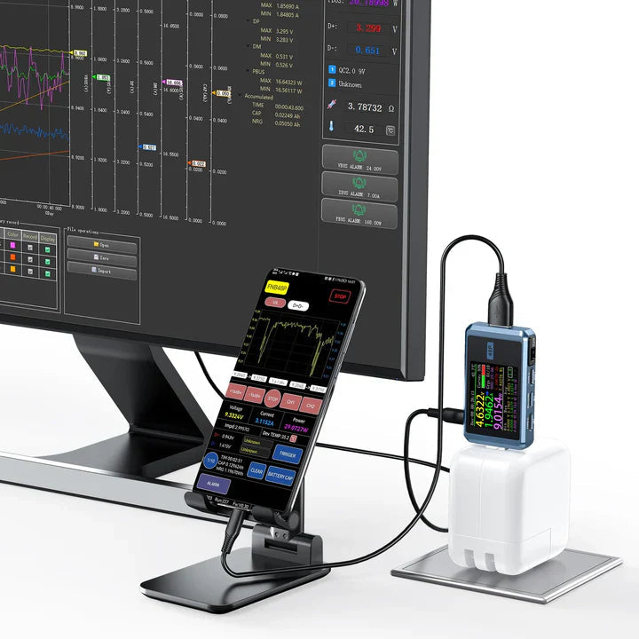Fr FNB48P Bt USB Tester Price - shown connected to a white power adapter and a smartphone, displaying real-time voltage, current, and power data on its screen.