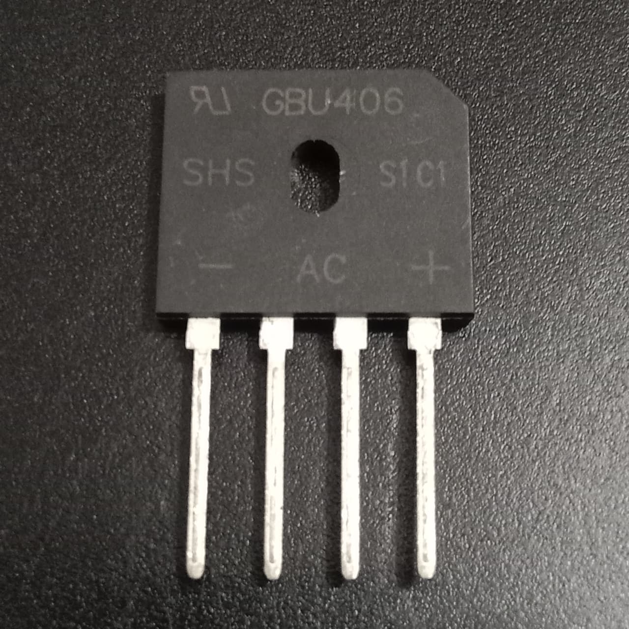 GBU406 4A 600V Single-Phase Bridge Rectifier USED - a black rectangular electronic component with four metal pins and printed markings including AC, +, and -.