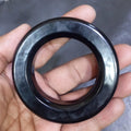 Gnt Ring For Inverter 3 Inch | High-quality Ferrite Core | Digilog.pk - a black, circular ferrite core held in a hand.