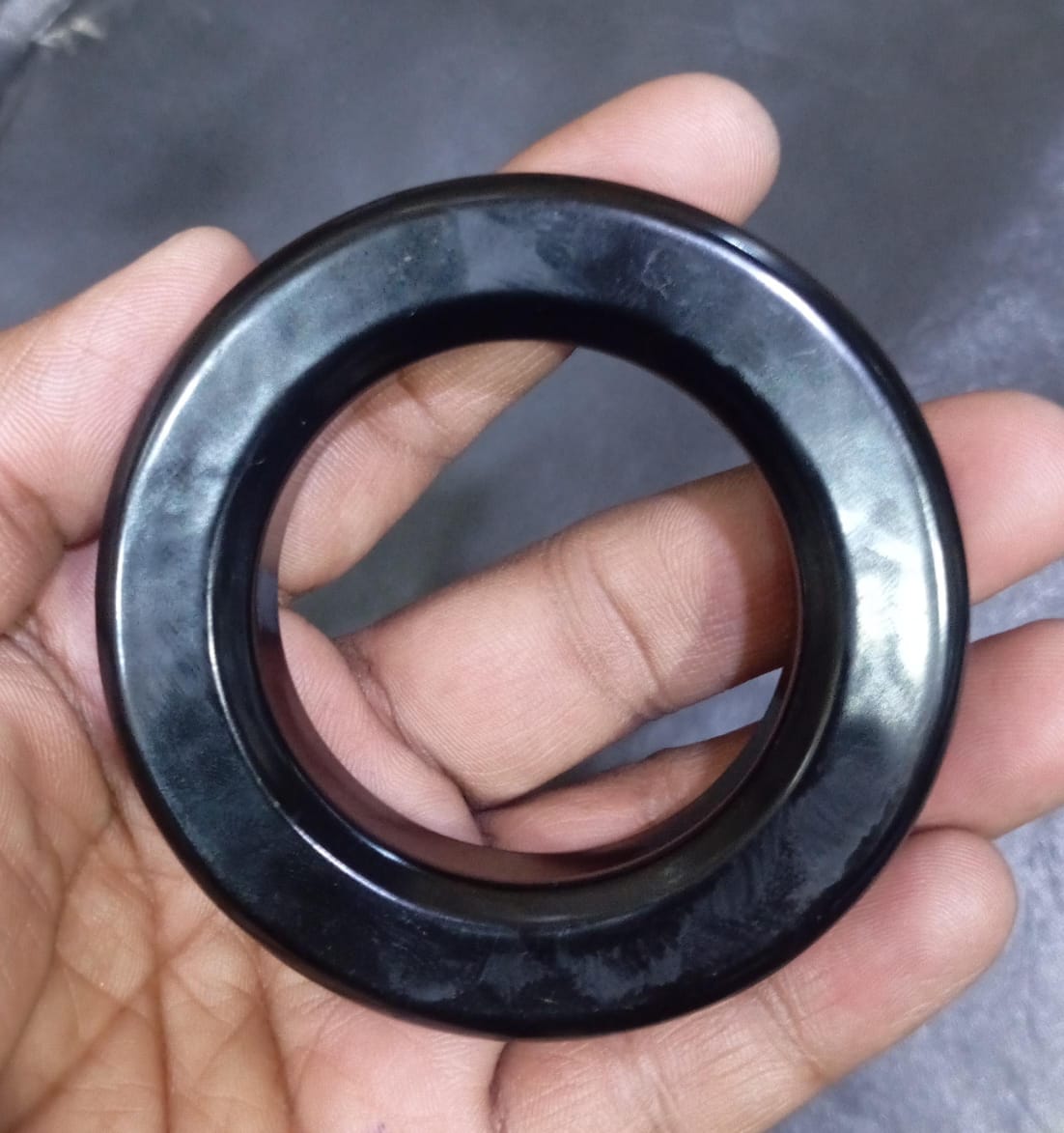 Gnt Ring For Inverter 3 Inch | High-quality Ferrite Core | Digilog.pk - a black, circular ferrite core held in a hand.