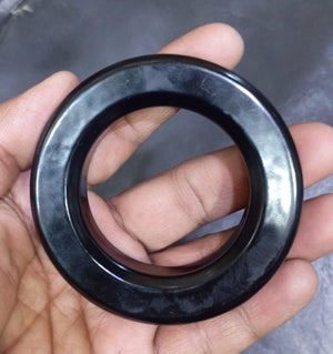 Gnt Ring For Inverter 3 Inch | High-quality Ferrite Core | Digilog.pk - a black, circular ferrite core held in a hand.
